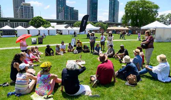 people sitting on the grass at a festival