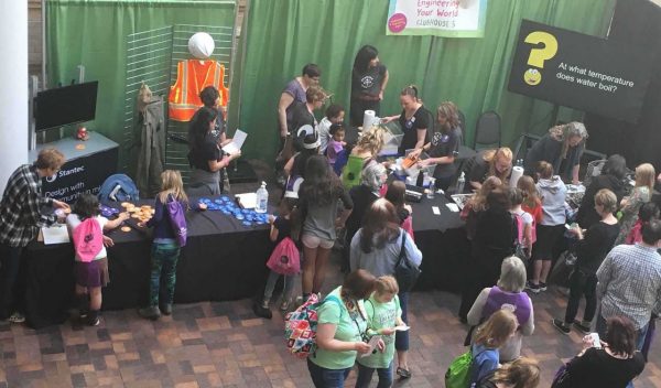 A group of students around a booth at a career fair