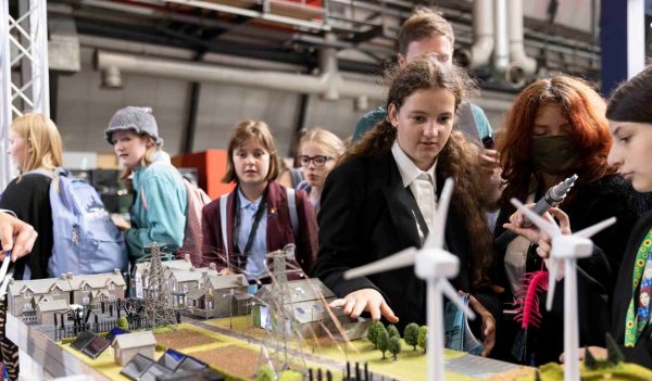 Students learning at a renewable energy booth.