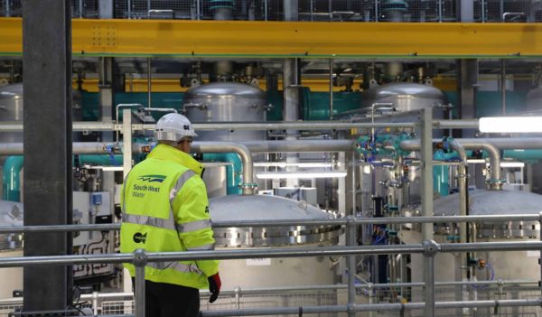 A worker in a tank room at a water facility