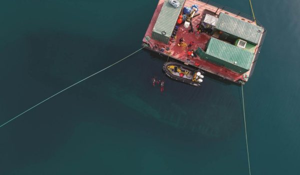 Qiniqtiryuaq (barge) above the Erebus site, wreck and divers visible.