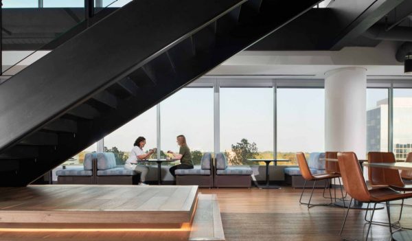 Staff common area with tables along large windows.