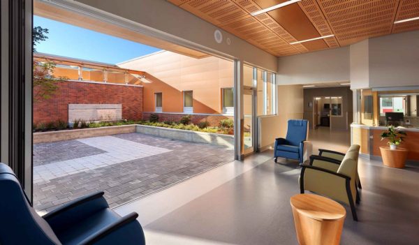 Waiting room with seating and an outdoor courtyard.