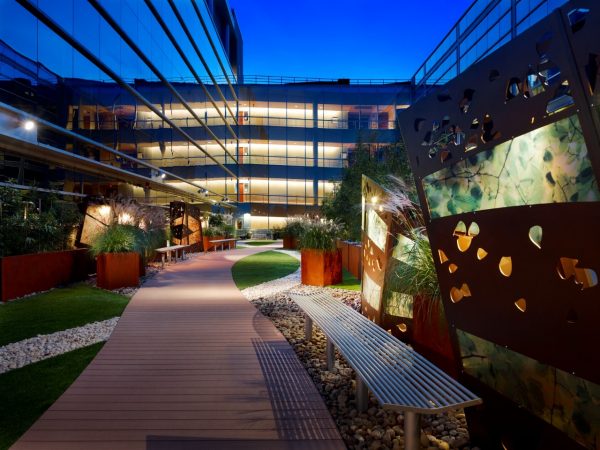 Landscaped walkway with art installations at night