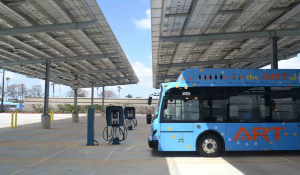 Bus parked in a row of vehicle charging stations.