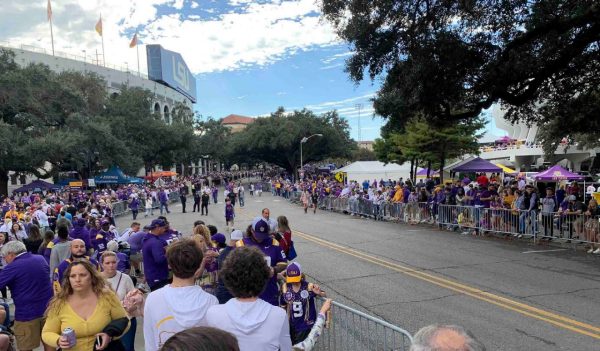 Event crowd along a route behind barricades.