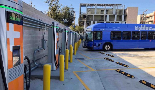 Bus parked in a row of vehicle charging stations.