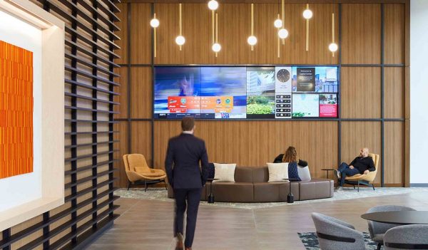 Lobby area with modern seating and a large tv screen feature wall.