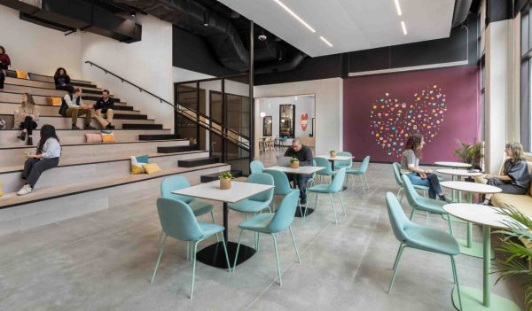 Staff lounge area with stepped seating and tables with chairs