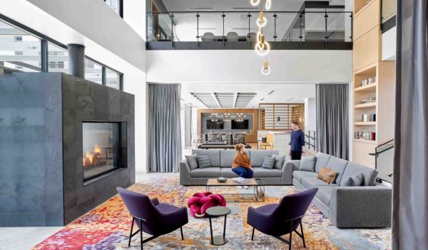 Lounge space with soft seating, fireplace, stairs and views to upper floor