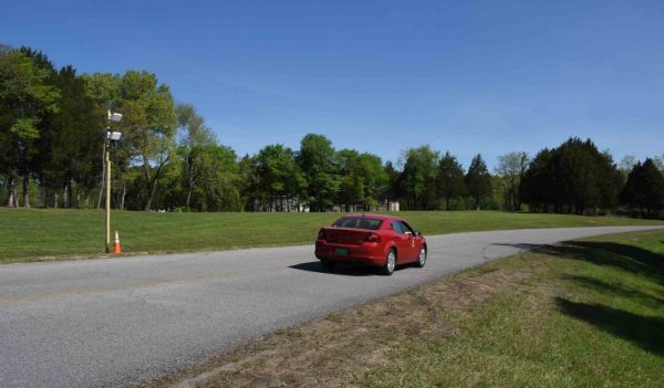 Car on the test road with monitoring equipment on the side