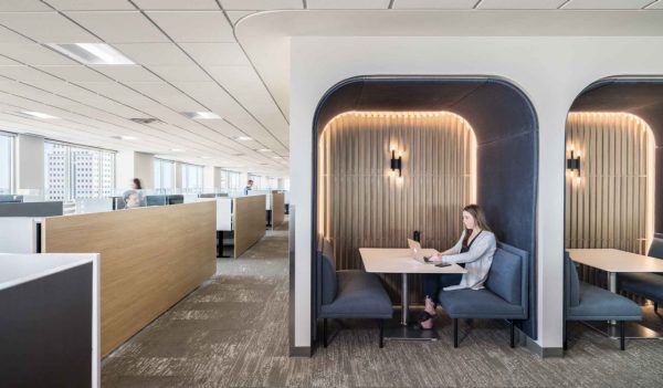 Woman sitting in a meeting pod on office floor.