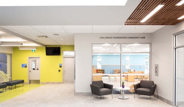 Interior reception area with a window into a children's activity area.