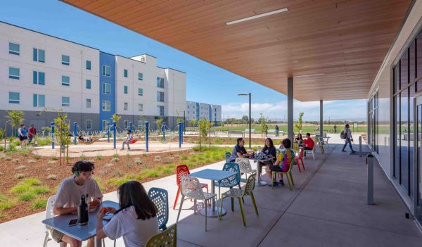 Students at tables on an outdoor covered patio