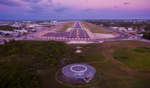 View of airport runway as a plane would approach it at dusk.