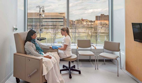 Patient receiving care from a nurse in a treatment room.