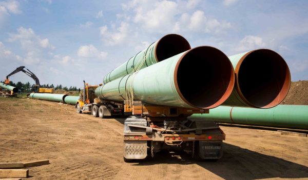 Lengths of steel gas pipes for installation on a flatbed truck at a construction site.