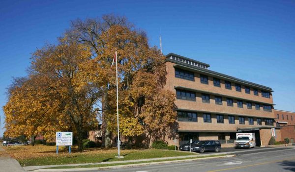 Exterior of the building from the street with signage and plantings