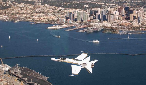 U.S. Navy Cmdr. Craig Reiner flies an F/A-18C Hornet strike fighter from Fleet Readiness Center Southwest over Naval Air Station North Island, Calif., and the aircraft carrier USS John C. Stennis (CVN 74The Hornet is painted to match that of the first F/A-18 flight on its 30th. (U.S. Navy photo/Released)